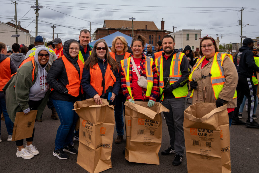 Campbell employees pose with bags and tools to clean up park
