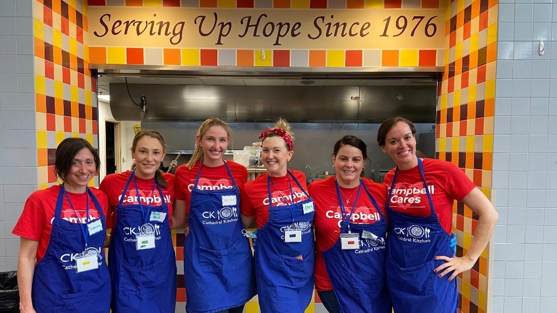 Employees pose in aprons in Cathedral Kitchen