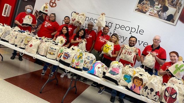 Employees in Goodyear pose with their filled backpacks
