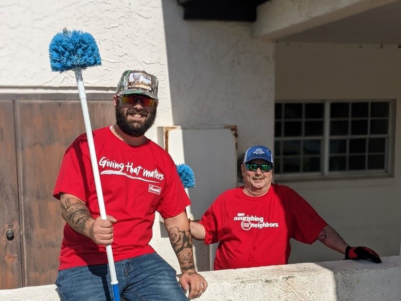 Employees pose with cleaning tools