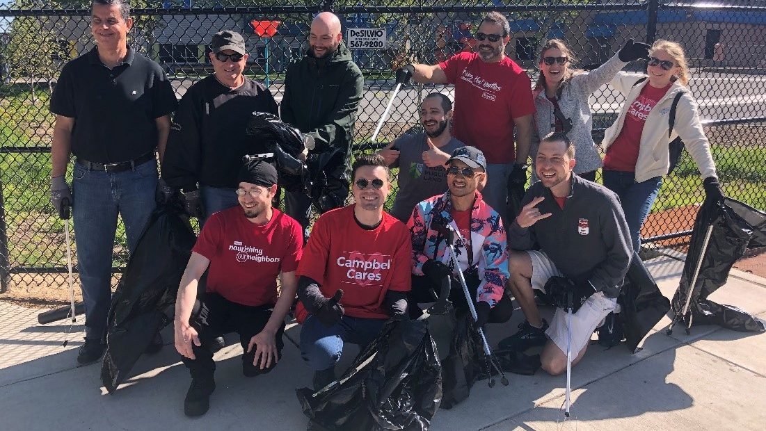 Employees pose with trash pickers