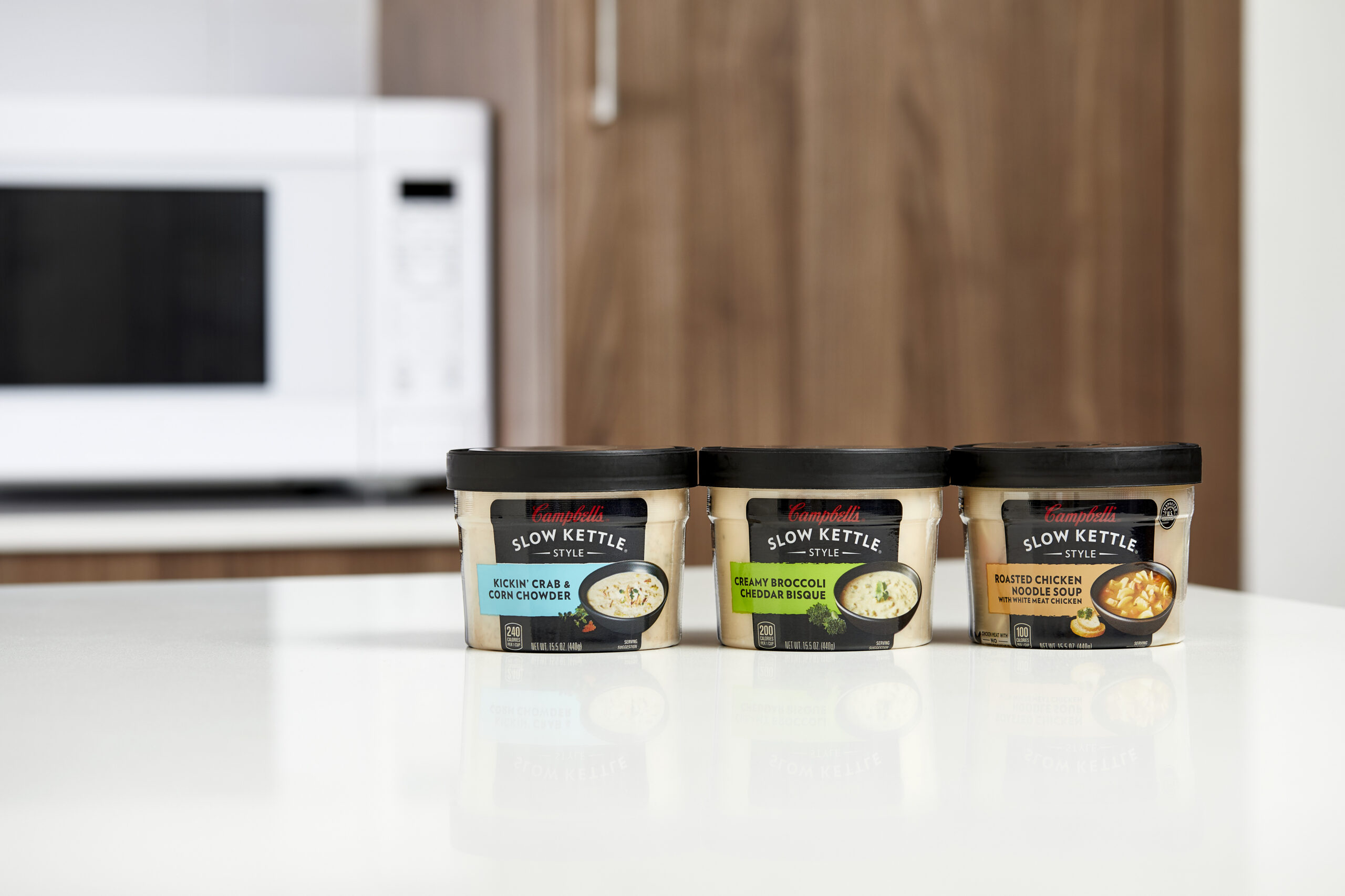 Various Campbell's Slow Kettle bowls, including Kickin' Crab & Corn Chowder, Creamy Broccoli Cheddar Bisque, and Roasted Chicken Noodle Soup